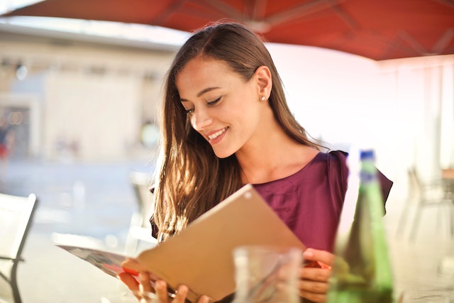 person looking at a menu on an outdoor patio